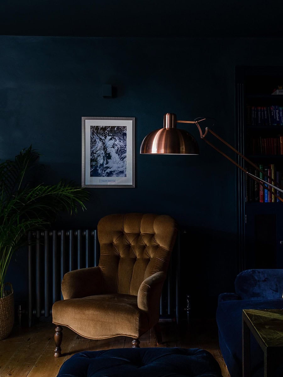Cambray House moody snug with velvet armchair, copper floor lamp and deep teal walls, Cotswolds